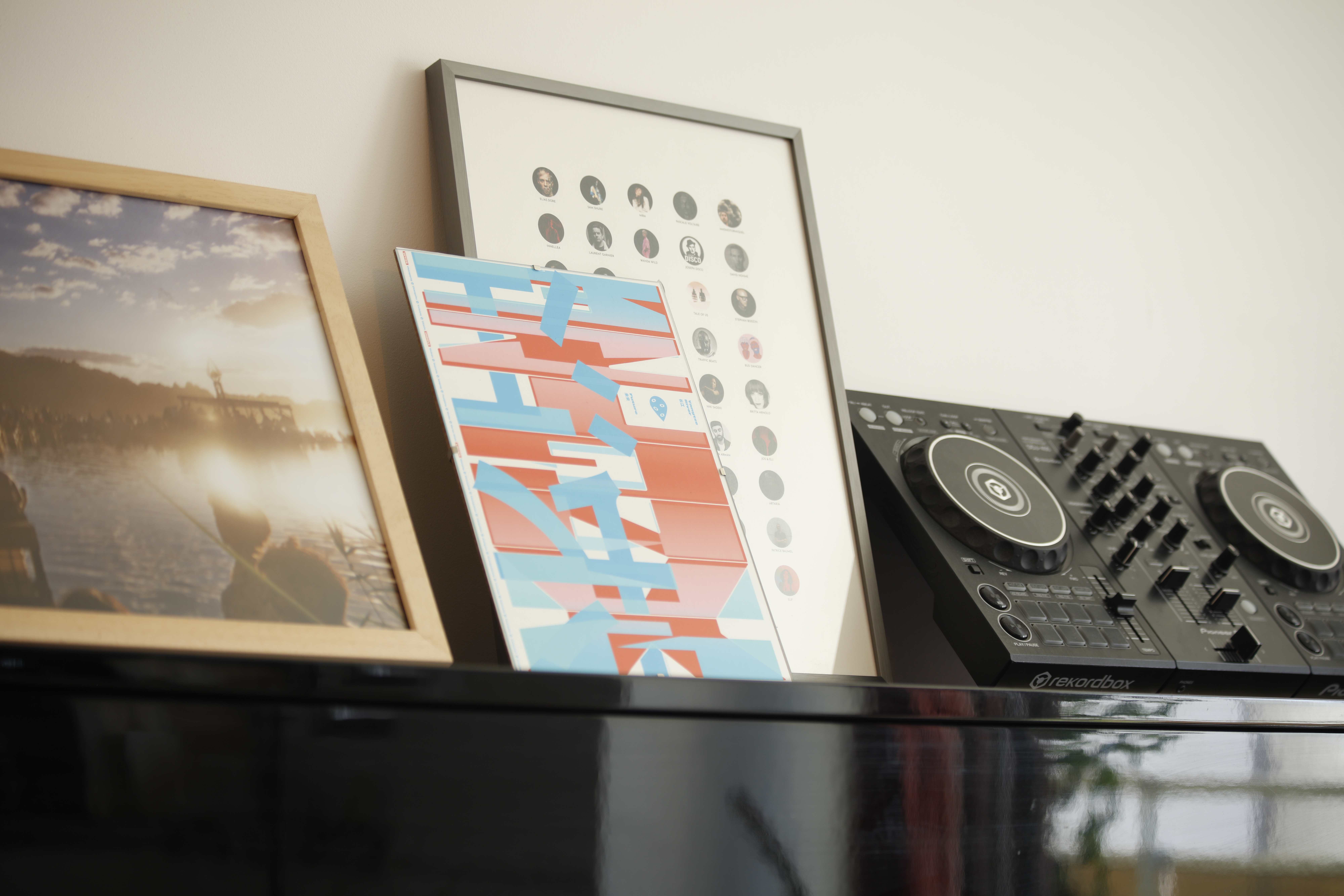 Studio setup with DJ controller and art prints