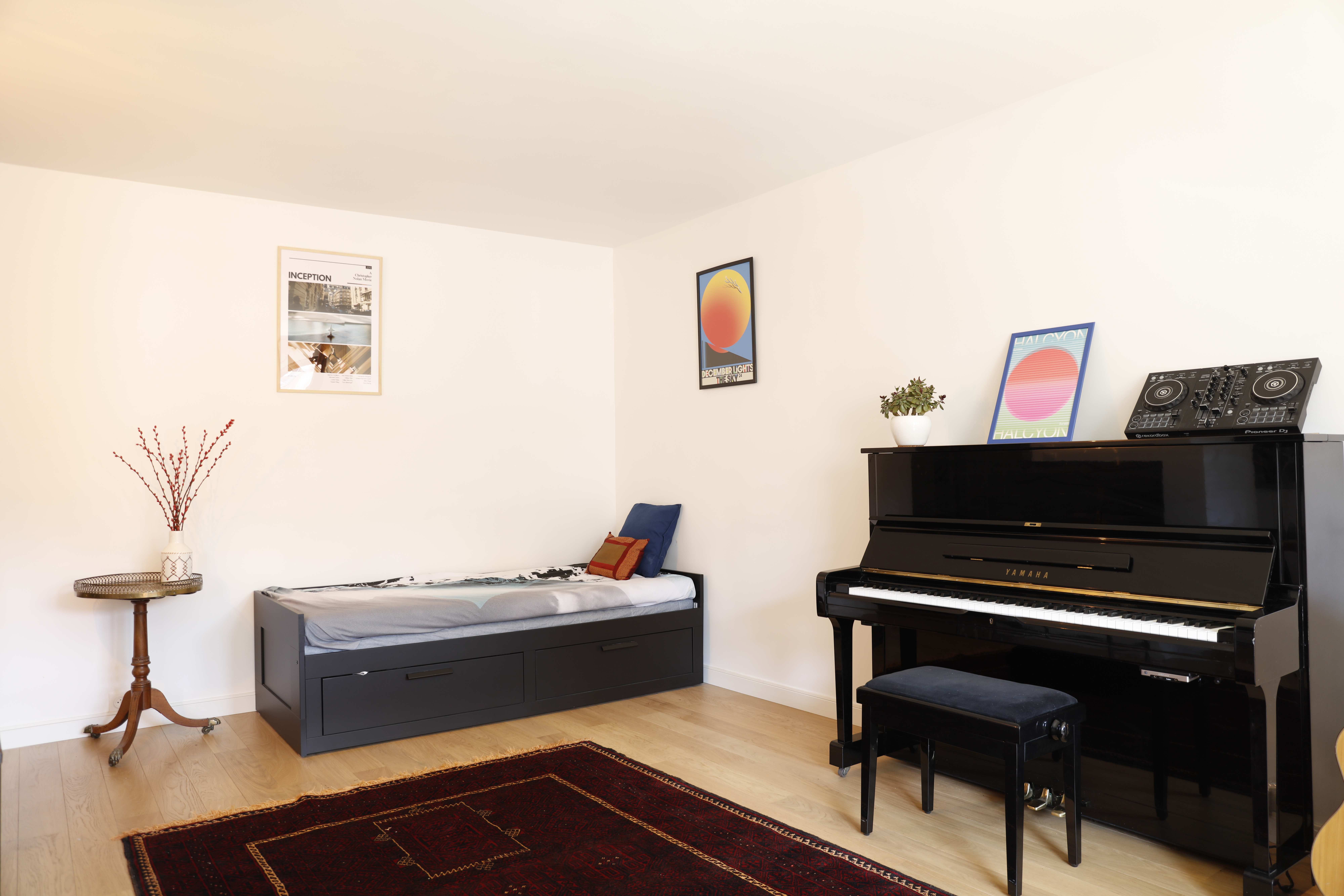 Music room with upright piano, DJ controller, and colorful art posters